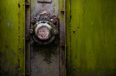 一个生锈的金属旋钮的特写一个绿色的保险箱

